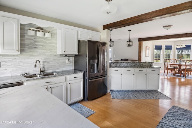 kitchen featuring stainless steel refrigerator with ice dispenser, light wood-type flooring, beam ceiling, decorative light fixtures, and white cabinetry