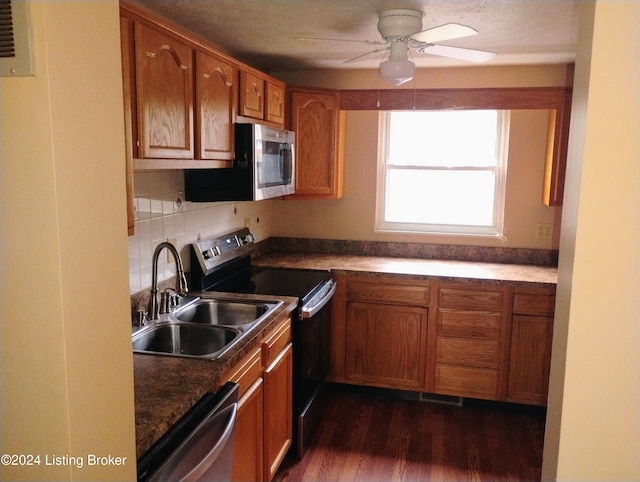 kitchen featuring backsplash, dark wood-type flooring, sink, ceiling fan, and stainless steel appliances