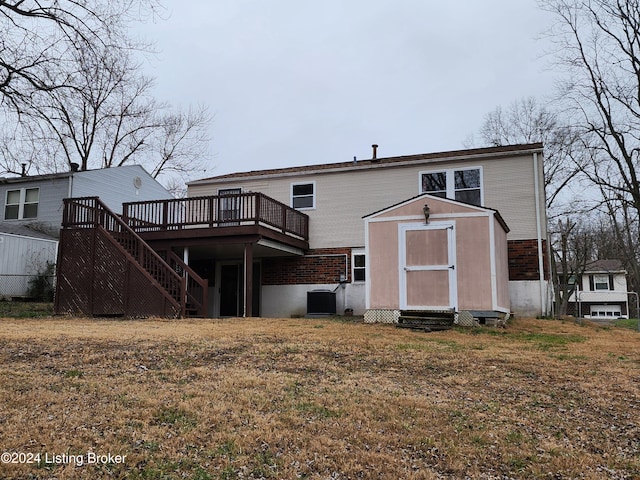 rear view of house with a lawn, central AC, a wooden deck, and a shed