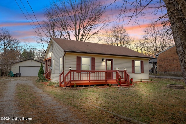 view of front of property with a lawn, a garage, an outdoor structure, and a wooden deck