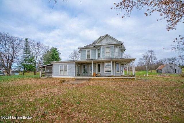 view of front of home with an outdoor structure, a front lawn, and a porch