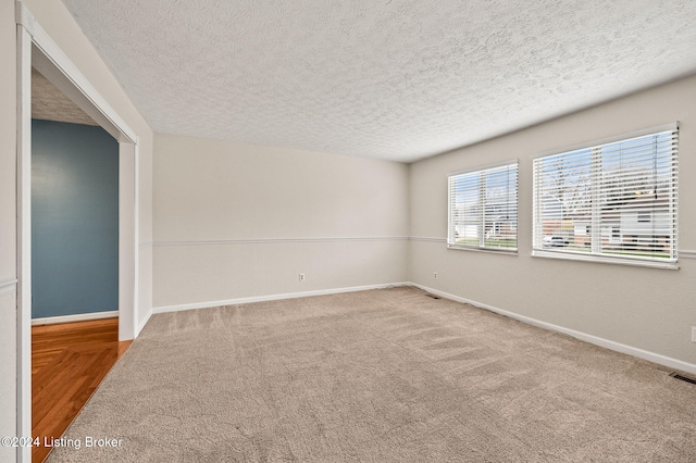 empty room featuring carpet and a textured ceiling