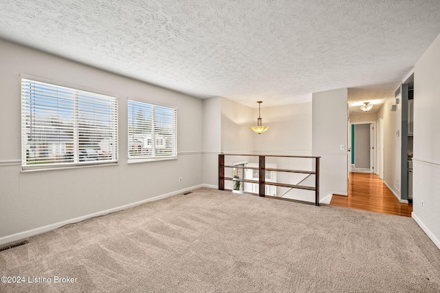 empty room with carpet flooring and a textured ceiling