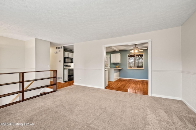 carpeted empty room featuring ceiling fan and a textured ceiling