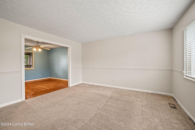 carpeted empty room with a textured ceiling and ceiling fan