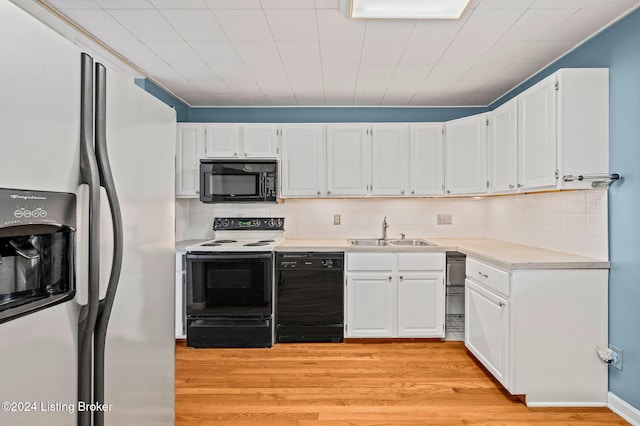 kitchen featuring sink, white cabinets, black appliances, and light wood-type flooring