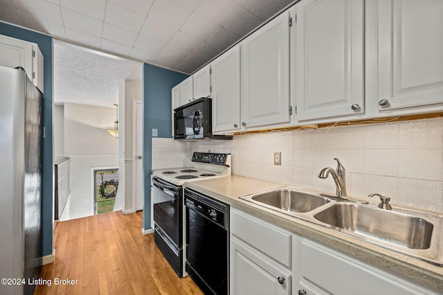 kitchen featuring light wood-type flooring, tasteful backsplash, sink, black appliances, and white cabinets