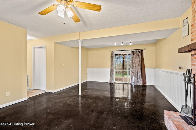 empty room with a textured ceiling, ceiling fan, and concrete floors