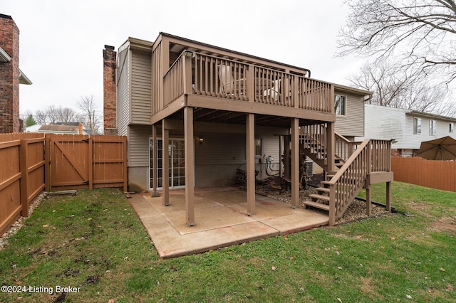 rear view of house with a patio area, a yard, and a wooden deck