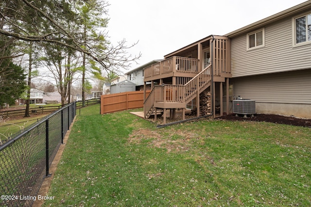 rear view of house featuring a yard, a deck, and central air condition unit