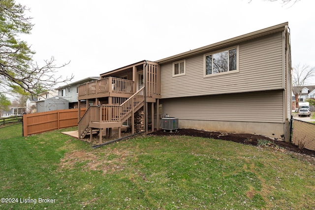 back of property featuring a lawn, cooling unit, and a deck