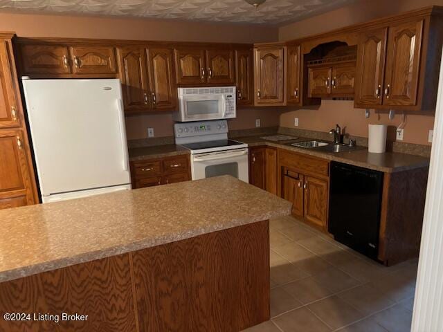 kitchen with tile patterned floors, sink, and white appliances