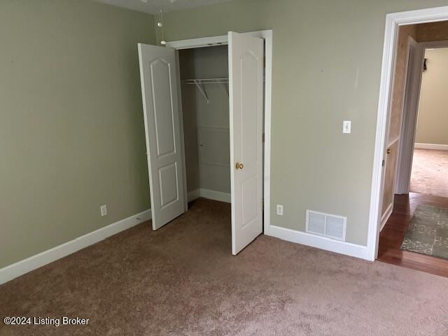 unfurnished bedroom featuring light colored carpet and a closet