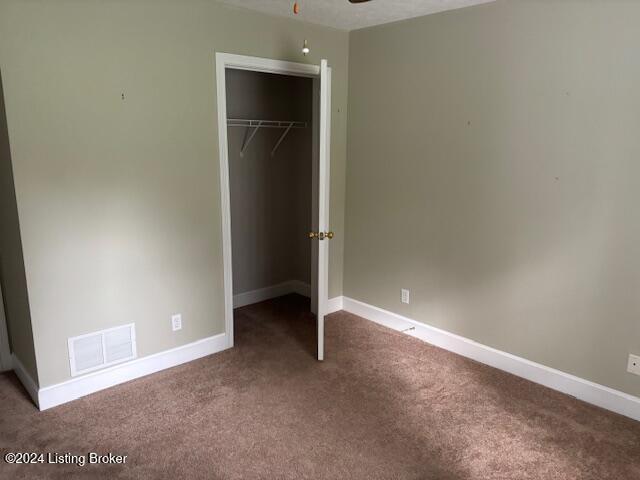 unfurnished bedroom featuring carpet floors and a closet