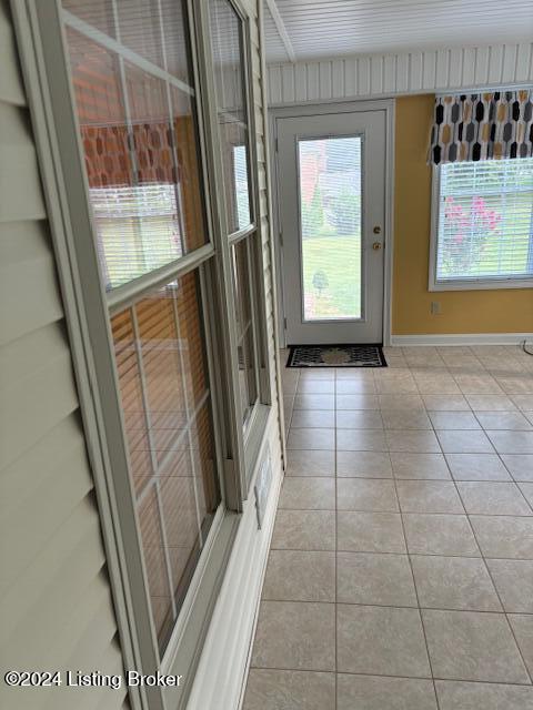 doorway to outside with light tile patterned floors