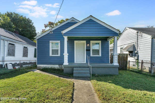 bungalow-style home with covered porch and a front lawn