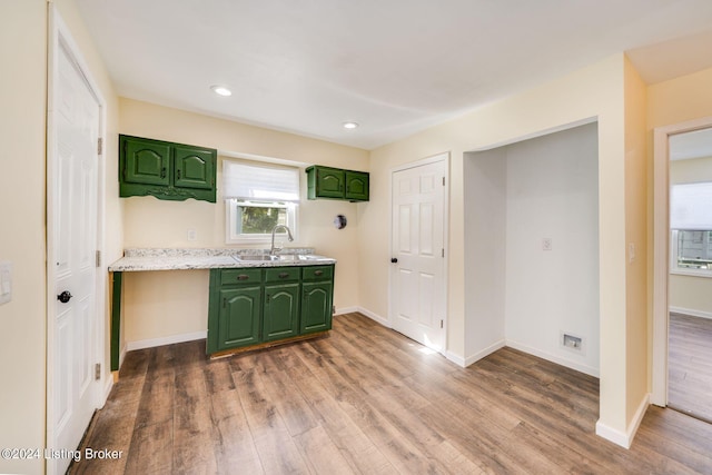 kitchen with hardwood / wood-style floors, green cabinetry, and sink