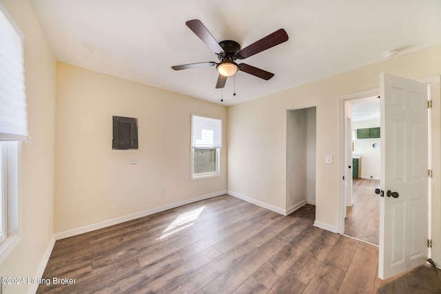 empty room with electric panel, ceiling fan, and dark hardwood / wood-style floors