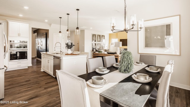 dining space featuring sink, a notable chandelier, and dark hardwood / wood-style floors