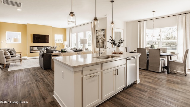 kitchen with sink, white cabinets, dishwasher, and hanging light fixtures