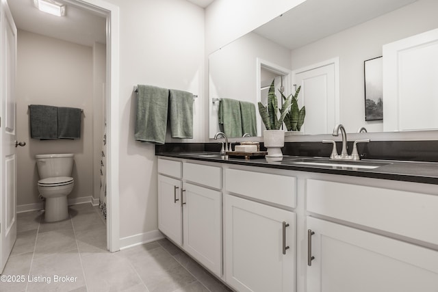 bathroom featuring toilet, vanity, and tile patterned flooring