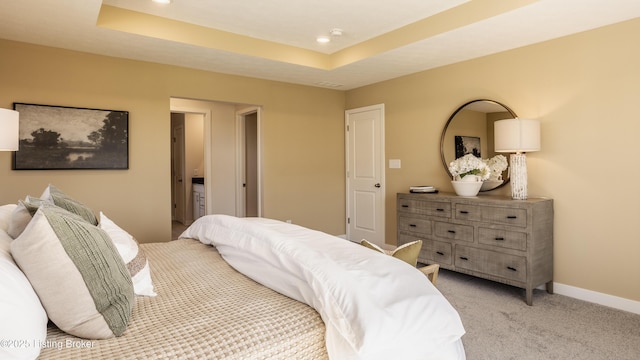 carpeted bedroom featuring a raised ceiling