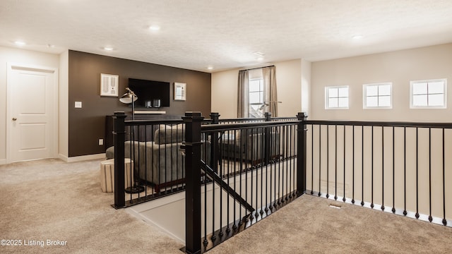 interior space with a textured ceiling and light carpet