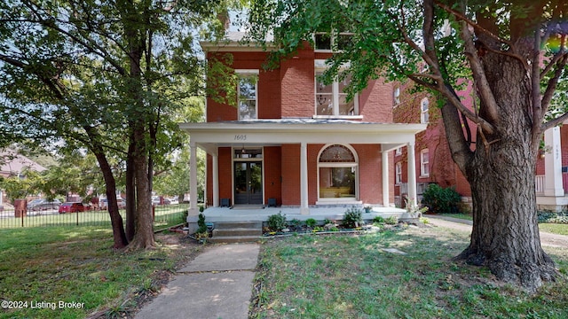 italianate house featuring covered porch and a front lawn