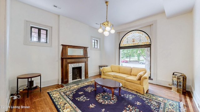 living room featuring a fireplace, dark wood-type flooring, and a notable chandelier