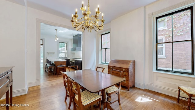 dining space featuring light hardwood / wood-style flooring and a notable chandelier