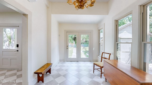 doorway to outside with a chandelier and a healthy amount of sunlight