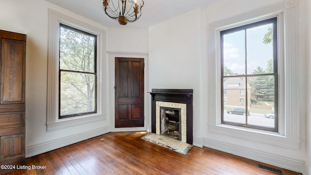 unfurnished living room with dark hardwood / wood-style flooring and a notable chandelier