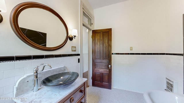 bathroom with tile patterned flooring, vanity, and tile walls