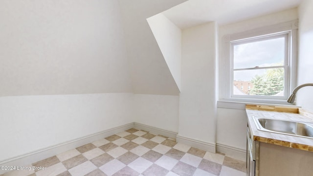 additional living space with sink and vaulted ceiling