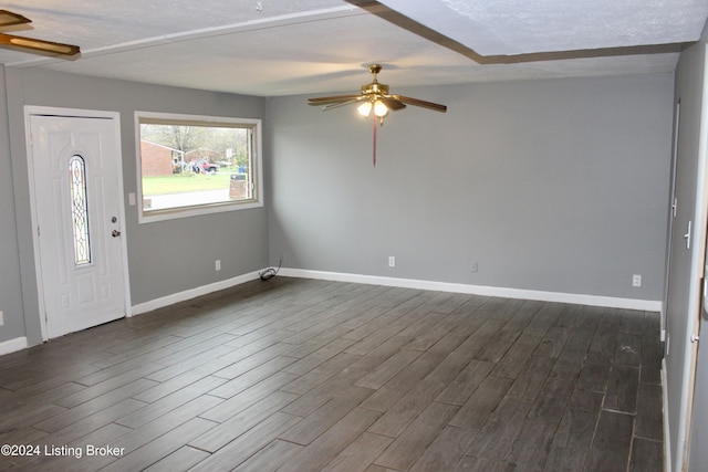 foyer with a textured ceiling, ceiling fan, and dark wood-type flooring