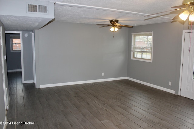 spare room featuring ceiling fan, dark wood-type flooring, and a textured ceiling