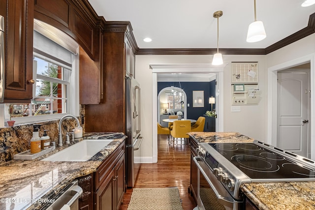 kitchen with a chandelier, appliances with stainless steel finishes, pendant lighting, dark wood-type flooring, and sink