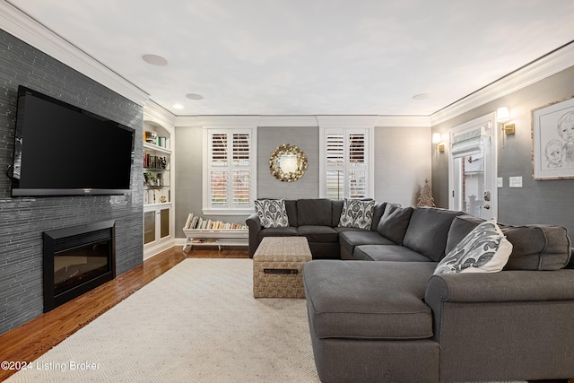 living room featuring built in features, ornamental molding, and wood-type flooring