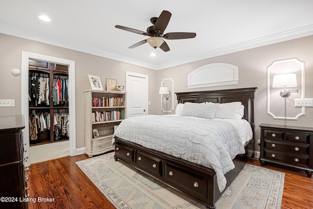 bedroom with ornamental molding, ceiling fan, a closet, and wood-type flooring