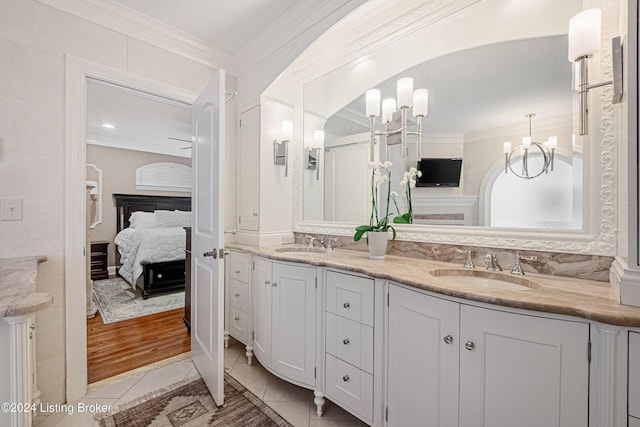 bathroom with ornamental molding, tile patterned flooring, an inviting chandelier, and vanity