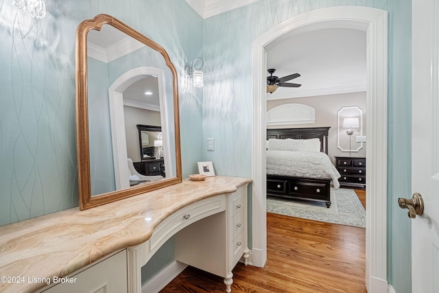 bathroom featuring ornamental molding, ceiling fan, vanity, and wood-type flooring