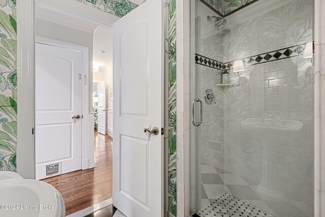 bathroom with walk in shower, ornamental molding, and hardwood / wood-style flooring