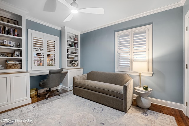 office space with ceiling fan, crown molding, built in shelves, and hardwood / wood-style flooring