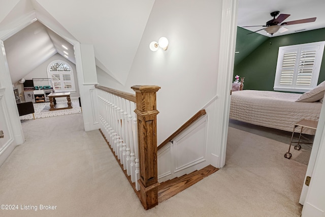 hallway featuring light carpet and vaulted ceiling