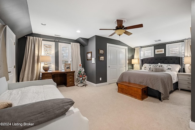 bedroom with ceiling fan, light colored carpet, a closet, and lofted ceiling