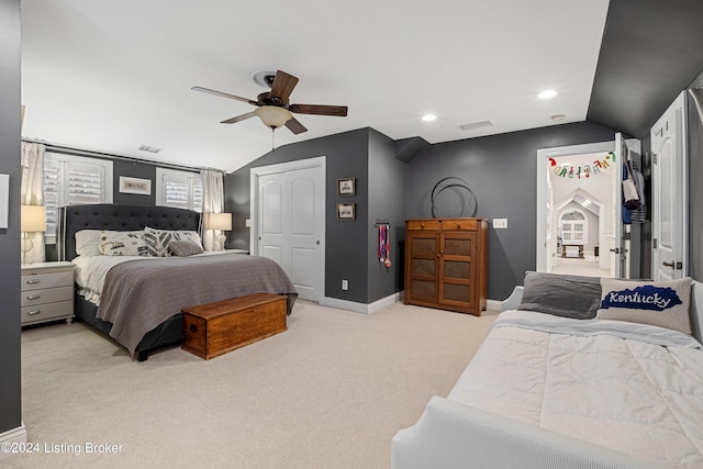 carpeted bedroom with vaulted ceiling, ceiling fan, and a closet