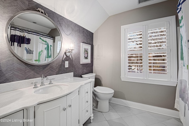 bathroom featuring tile patterned floors, vaulted ceiling, vanity, and toilet