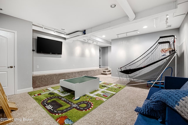 playroom with rail lighting, beamed ceiling, and carpet