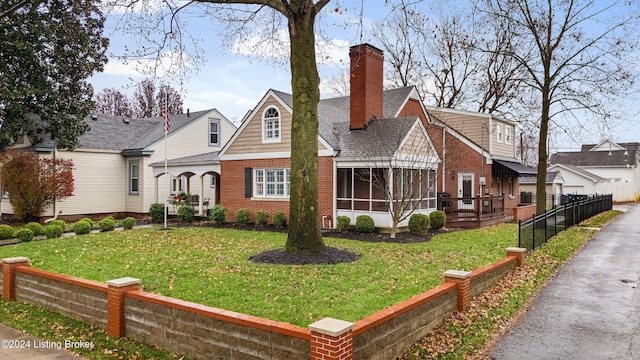 view of front of home featuring a front yard and a sunroom