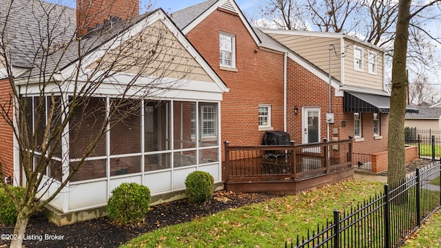 back of property featuring a deck and a sunroom